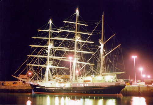 Image of a well lit ship at night in a body of water