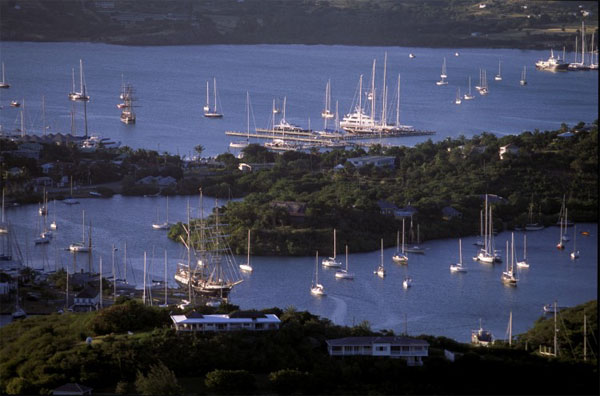 A harbor with sail boats all scattered around during dusk.