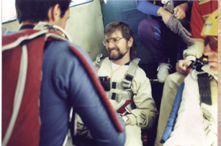 Gene smiling inside of a plane with his sky diving instructor