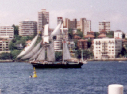 A ship in a body of water with a city in the background