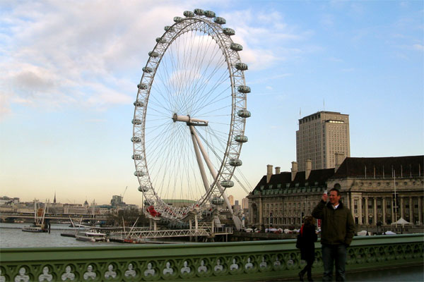 A group of people standing in front of London Eye