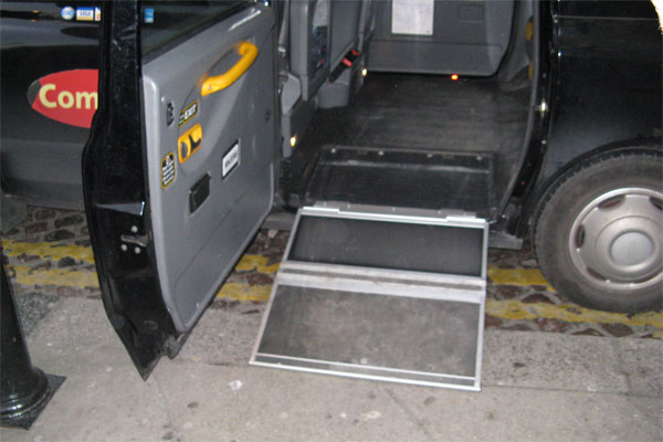 A ramp that pulls out of the backseat of a taxi van.