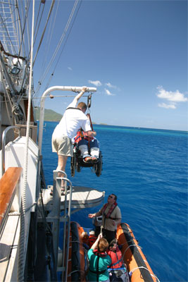 Gene getting lowered into the dingy while in his wheel chair.