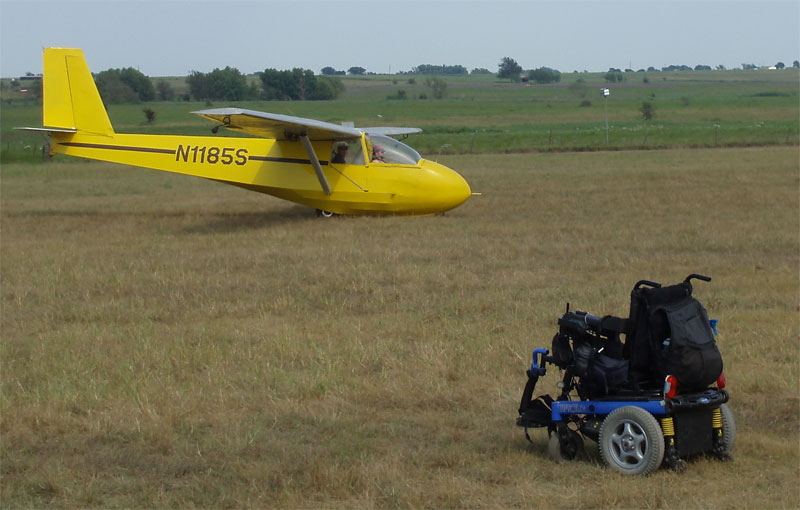 View of Gene's chair in a field with the sailplane in the far background.