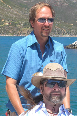 Gene and a friend smiling next to a body of water