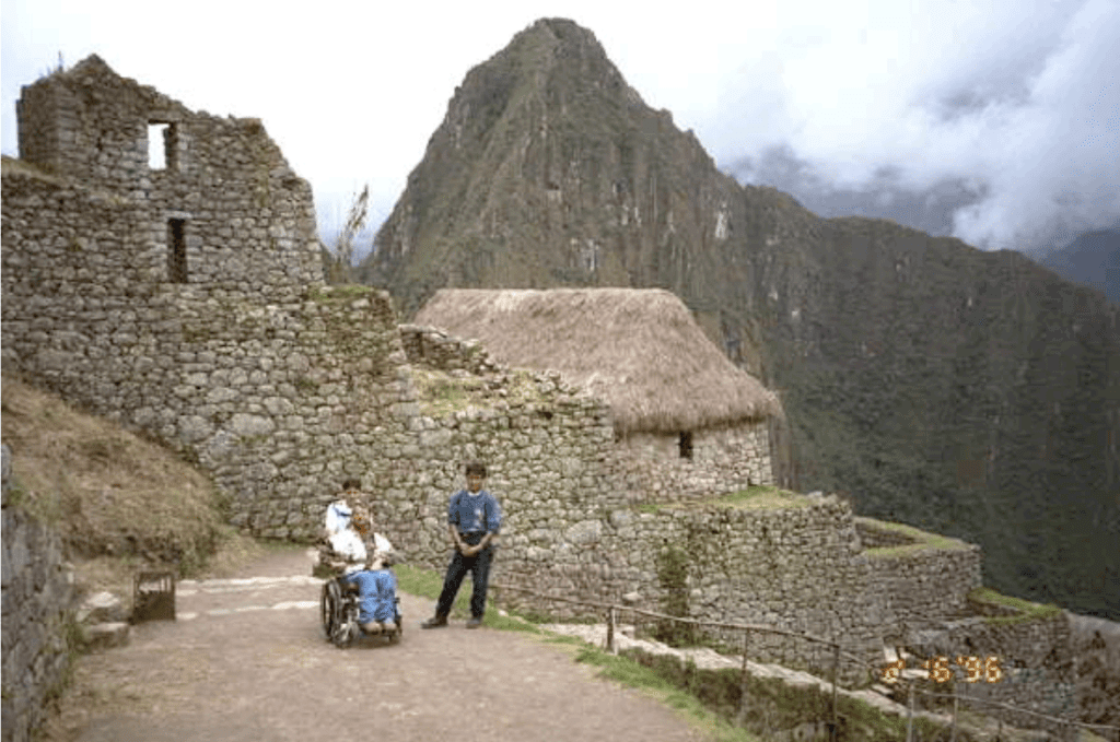 Gene in Peru with a tour guide, the large mountains of Peru are behind the group.