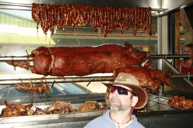 Gene stands in front of cured meats in a Puerto Rican market.