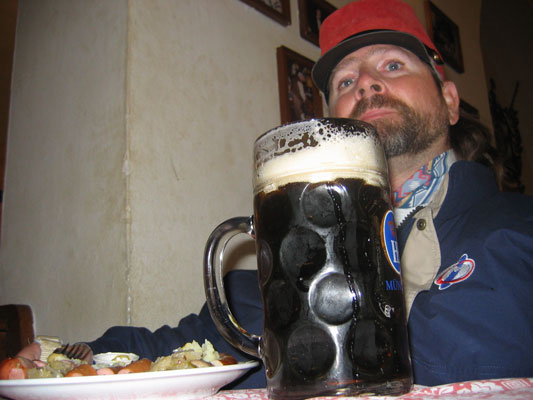 Gene poses with a very large dark beer