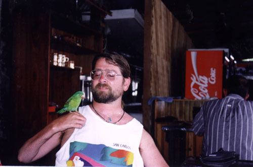 Gene wearing a white shirt holding a bird