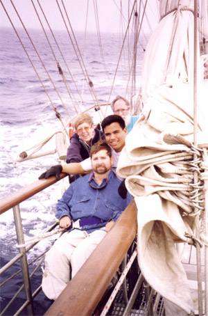 Gene with 3 other peopleon thee bowsprit of a ship