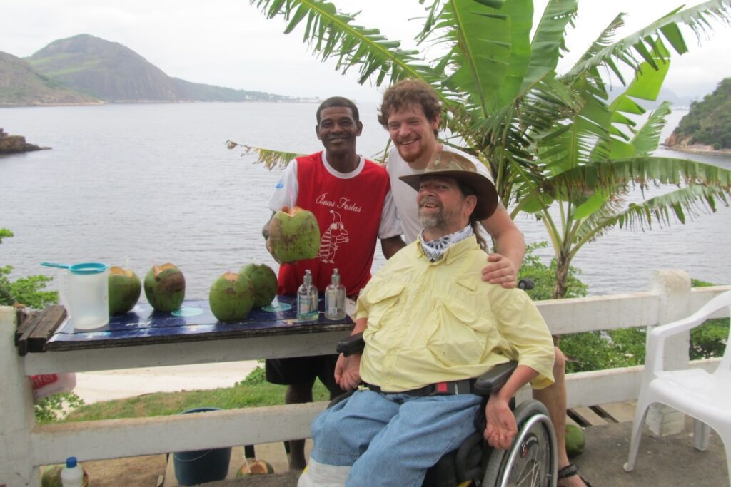 Genes smiling with a young boy holding a coconut.