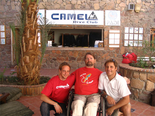 Gene and his diving buddies sitting on a bench posing for the camera