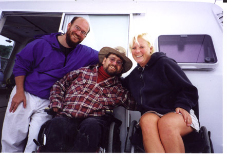 Gene in the center, with a man to his left, and a woman to his right, on the ship deck