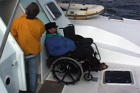 Dave inspecting the hatch of the ship with Gene sitting on the deck