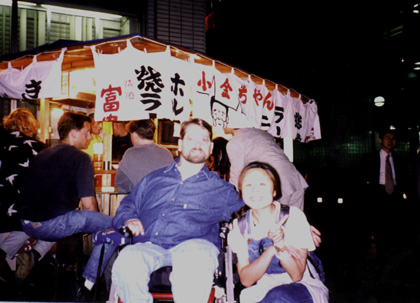 Gene and a lady squatting beside him.