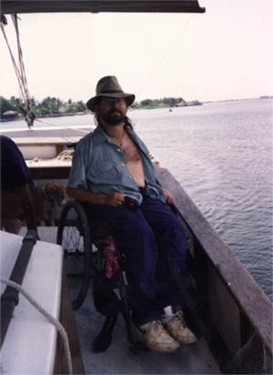 Gene on a boat in Ghana near the stern while in his wheel chair
