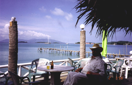 A person sitting at a table in front of a body of water