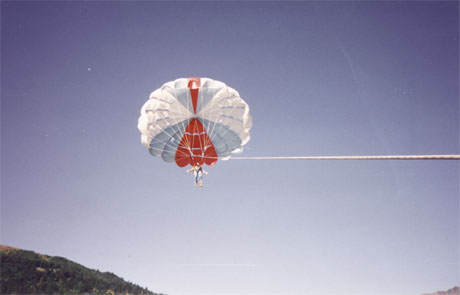 Gene far up in the sky on a parasail