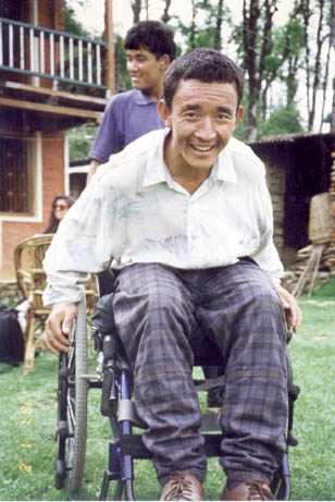a man sitting in a wheelchair smiling at the camera