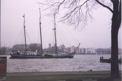 A boat is docked next to a body of water in Amsterdam
