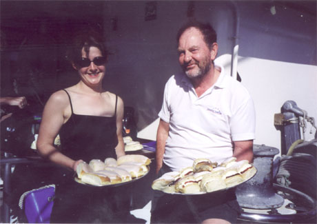 A man and a woman posing with food in a tray
