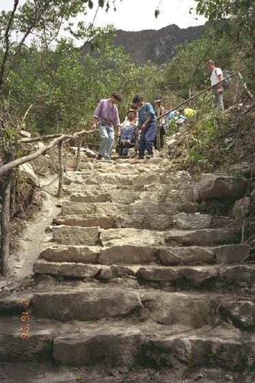 Gene and guides navigate steps on a mountain in Machu Picchu