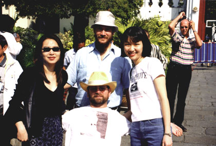 Gene smiling outside in Thailand with a group of friends