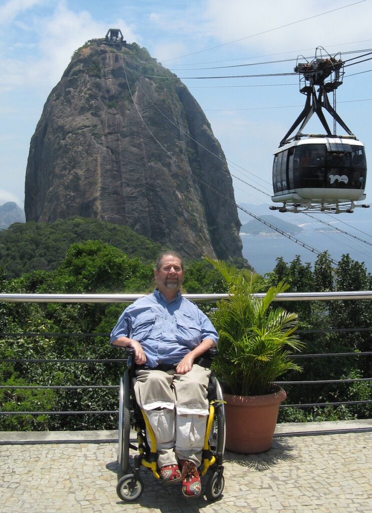 Gene sitting in front of a tall narrow mountain in Brazil