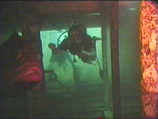 a person swimming through the doorway of a wrecked ship