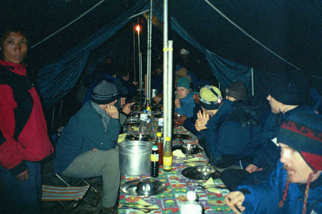 A group of people gathered inside of a tent.