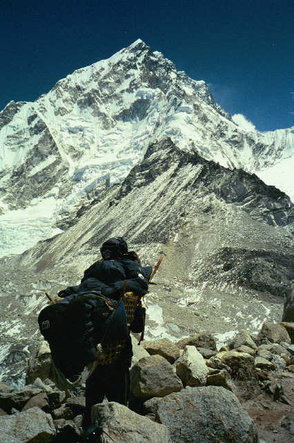 Gene with a sherpa and a Mount Everest is seen behind them.