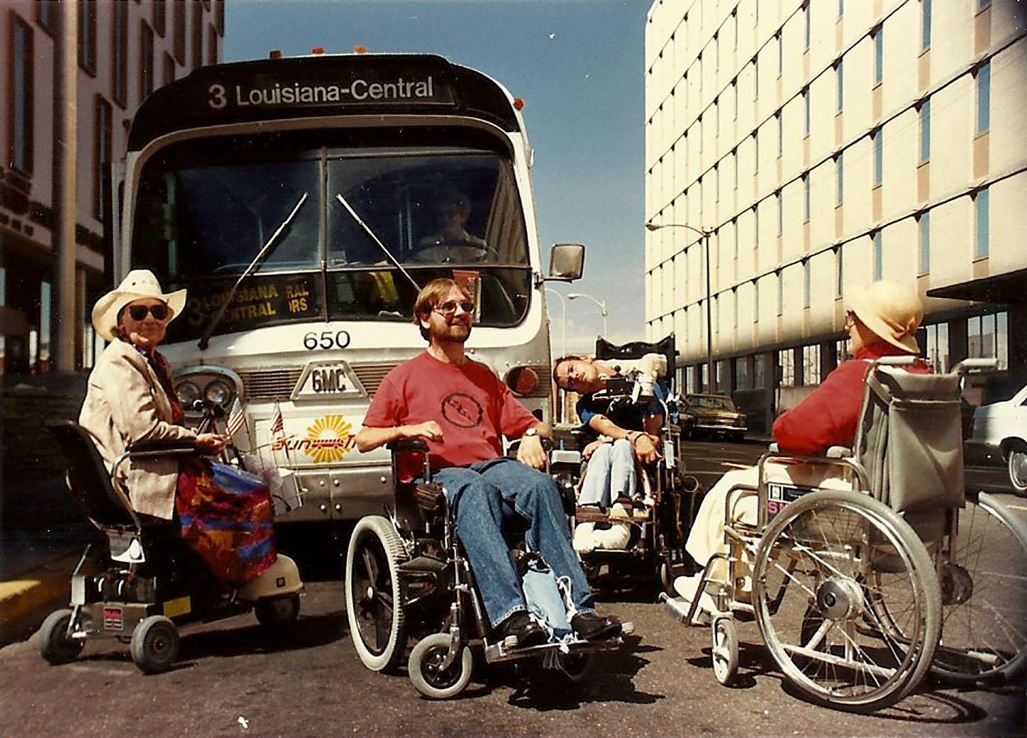 Gene blocks bus with 3 other protesters in wheelchairs
