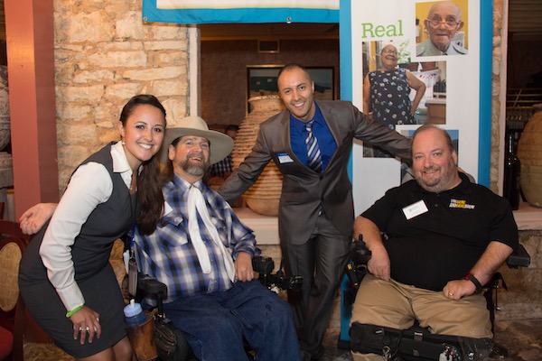 3 men, 2 in a wheelchair and a woman smiling 