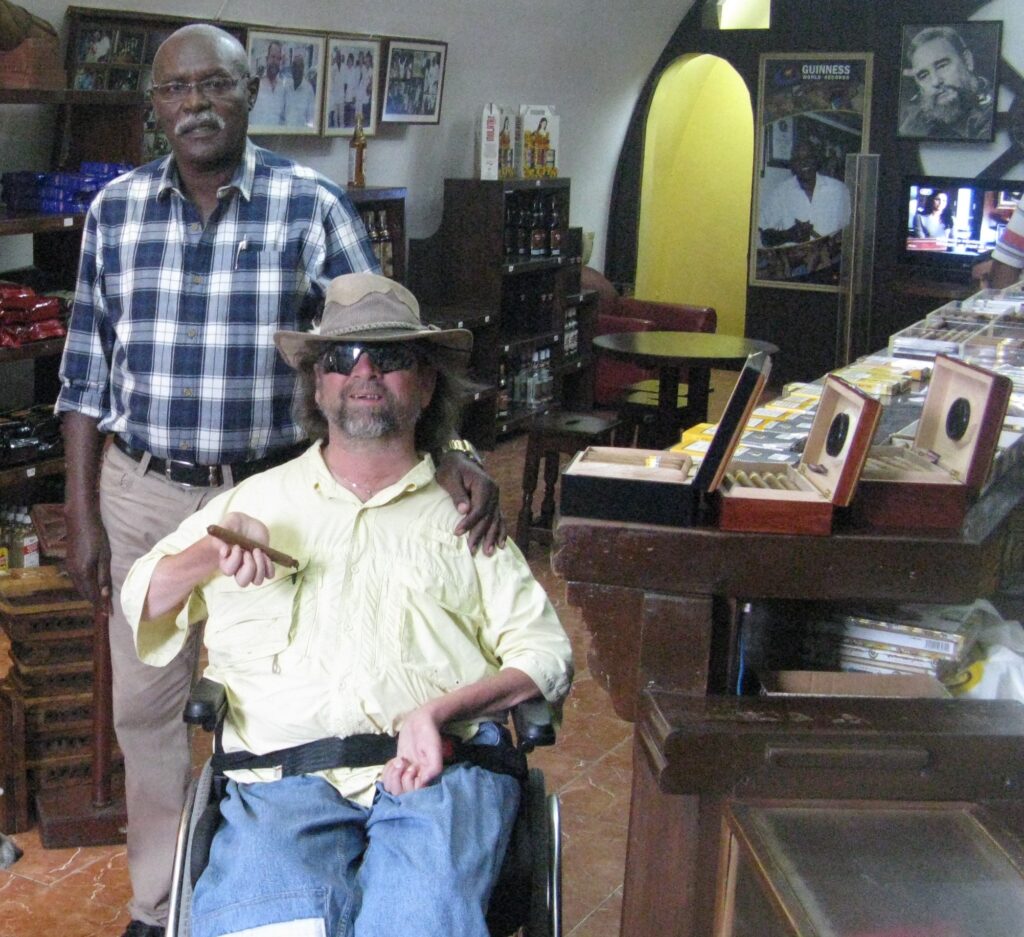 Gene poses with Jose Cueto while holding a cigar.