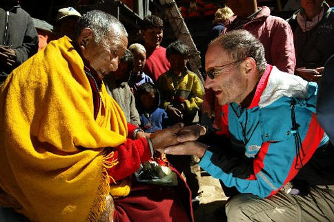 A monk blesses a man.