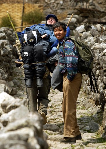 Gene being carried by a sherpa while in a modified bamboo basket.