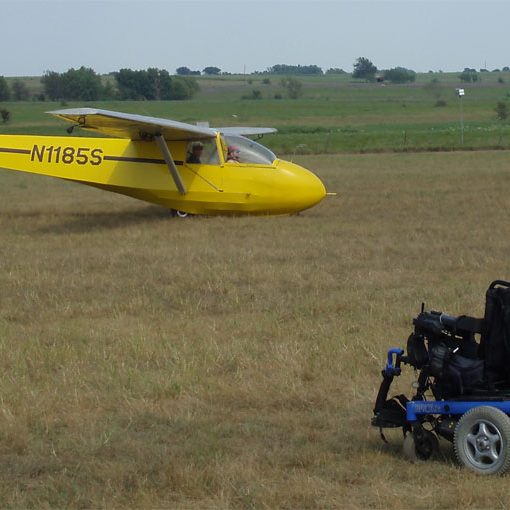 View of Gene's chair in a field with the sailplane in the far background.