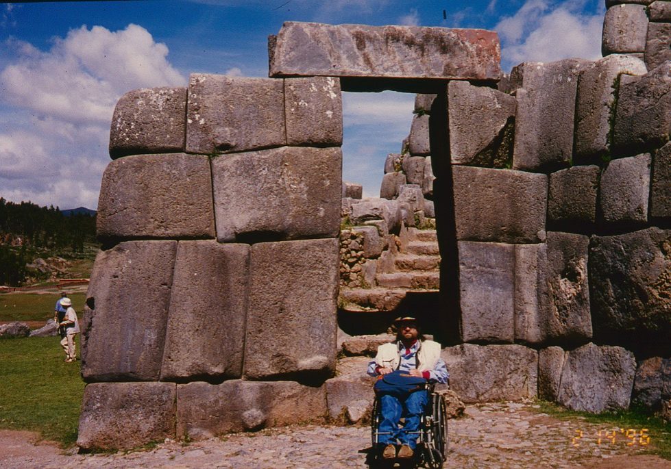 Gene sits in front of stone wall built by the Inca