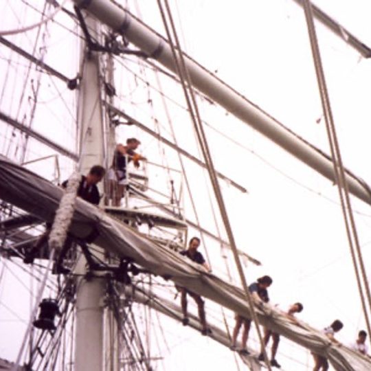 Gene is seen up high in the mast of a ship.