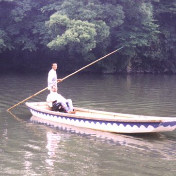 Gene with a man rowing a boat on water