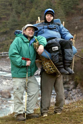 Gene with his brother, Robert. Gene is bundled up wearing a winter coat and is being carried by a sherpa.